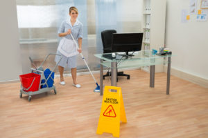 Young Maid Cleaning Floor With Mop In Office